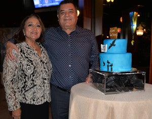 El cumpleañero Roberto López y su esposa Sonia de López posando con el pastel.