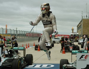 Mercedes AMG Petronas driver Lewis Hamilton of Britain leaps from his car as he celebrates winning the United States Formula One Grand Prix at the Circuit of The Americas in Austin, Texas on October 25, 2015. Hamilton won a third Formula One world title on Sunday when he swept to victory in the United States Grand Prix.                AFP PHOTO / MARK RALSTON